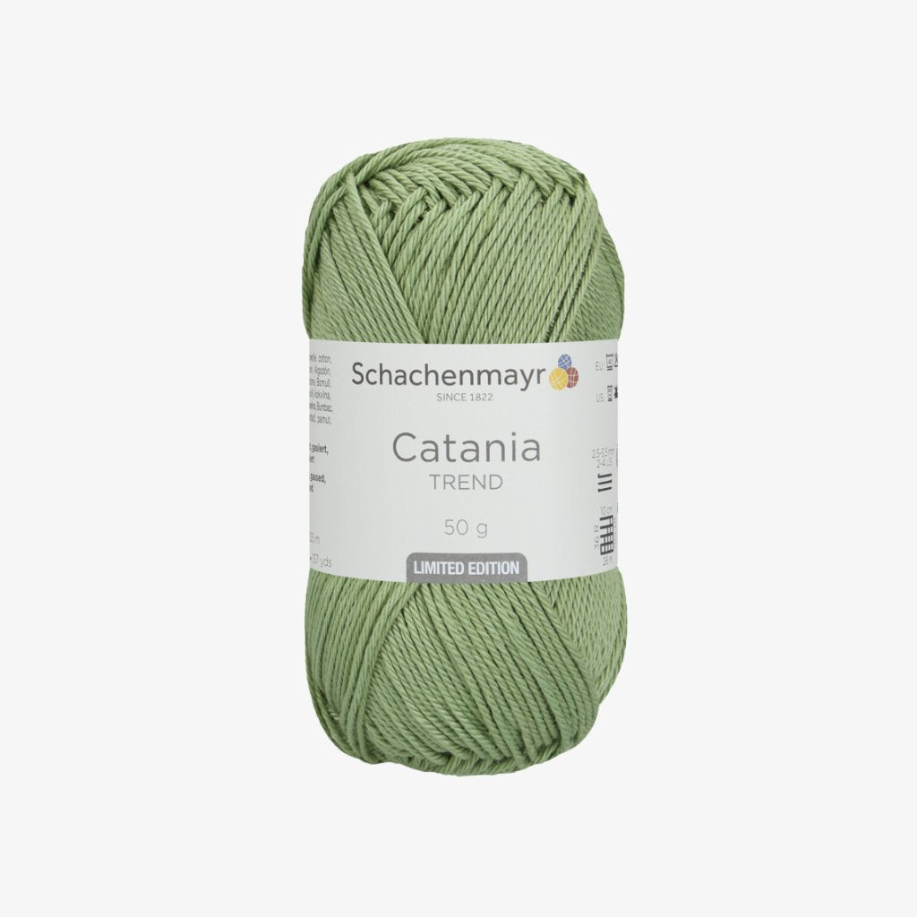 Schachenmayr Catania Garn in Grün mit weißer Banderole auf grauem Hintergrund.